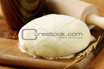 fresh dough with flour on wooden board