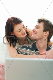 Happy young couple looking in laptop