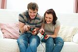 Cheerful young couple playing console