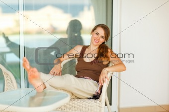 Happy young woman relaxing on terrace