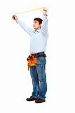Full length portrait of construction worker measuring with ruler