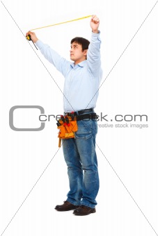 Full length portrait of construction worker measuring with ruler