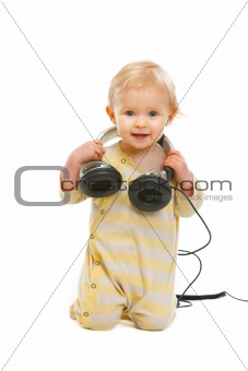 Happy baby with headphones looking on copyspace isolated on white