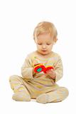 Lovely kid playing with rattle on floor isolated on white