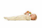 Cute kid laying on floor with rattle isolated on white