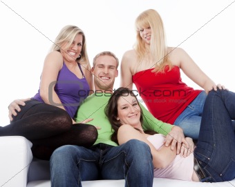 four young friends sitting on sofa smiling, embracing  