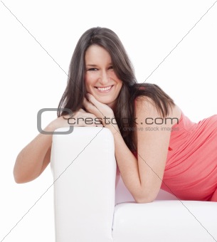 portrait of a young woman with dark hair on a sofa smiling