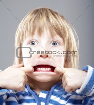boy with long blond hair making scary faces - isolated on gray