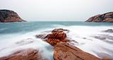 rocky sea coast and blurred water in shek o,hong kong 