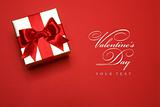 art golden gift box with a red bow on red background