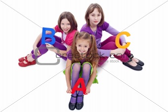 Young school girls holding letters of abc