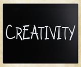 The word "Creativity" handwritten with white chalk on a blackboa