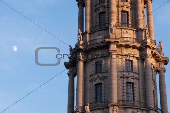 Cupola of the ALTES RATHAUS, BERLIN, GERMANY, with the red light of late afternoon illuminating the pillars and the moon in the background against a clear blue sky