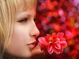 Closeup profile of beautiful blond woman with flower on red background.jpg