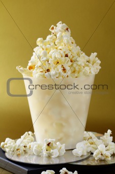 cup of popcorn and DVD disks on a gold background