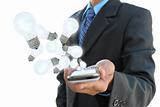 businessman hand holding mobile phone and light bulb