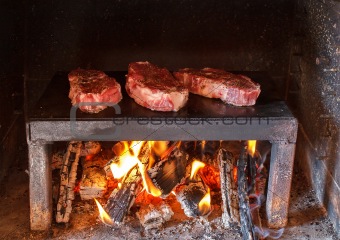 pork steaks preparing on the on a stone plate