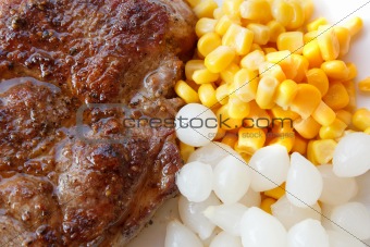 grilled pork steak with corn and small onions