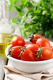 cherry tomatoes, olive oil and parsley on wooden background