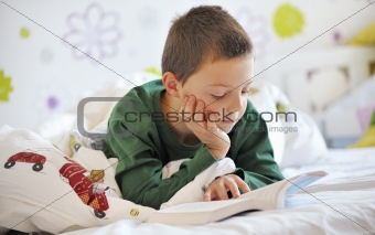 boy reading a book in bed