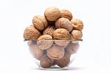 Walnuts are a lie in a glass bowl isolated on a white background
