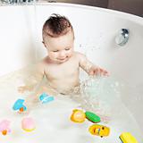 Cute smiling baby having fun and splashing water while taking a bath