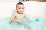 Cute baby having fun and smiling while taking a bath