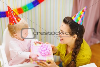 Mother giving birthday gift for baby