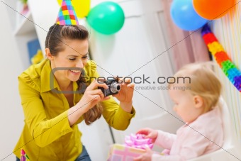 Mother making photos at babies birthday party
