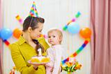 Portrait of baby and mother with birthday party cake