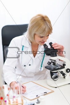 Senior doctor woman working with microscope