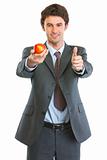 Modern business man showing apple and thumbs up