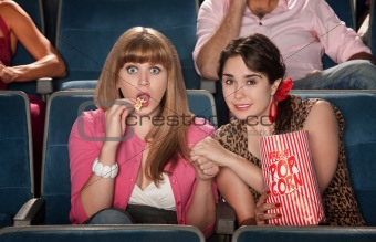Women With Popcorn Holding Hands