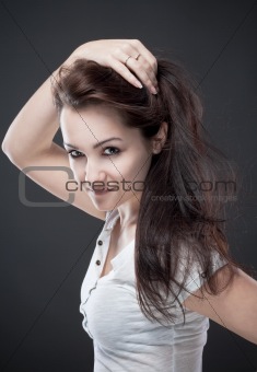 portrait of a teenage girl with brown hair against gray background