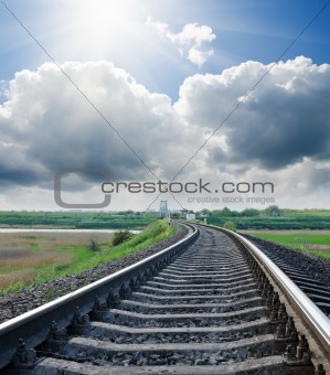 railway to horizon under cloudy sky