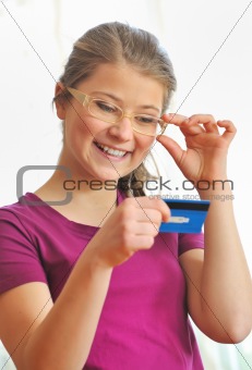 teenage girl holding up a credit card.