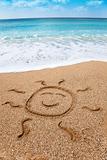drawing smiling sun symbol on the beach