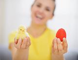 Woman holding red Easter egg and chicken