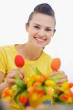 Smiling woman decorating bouquet of flowers for Easter