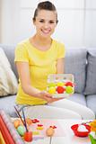 Smiling woman showing tray with colorful Easter eggs
