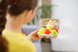 Woman holding tray with colorful Easter eggs and chicken