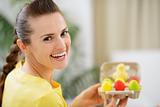Happy woman holding tray with colorful Easter eggs