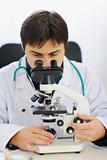 Male researcher working with microscope