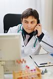 Medical doctor speaking phone at office