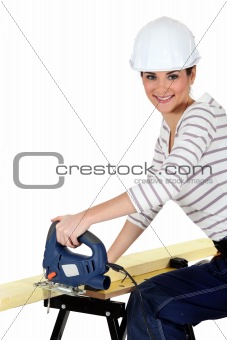 Woman cutting wood with a jigsaw