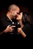 Happy Young Mixed Race Couple Holding Wine Glasses Against A Black Background.