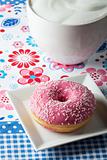 pink donut and a cup of cappuccino 