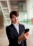 young businesswoman watching smart phone in hand
