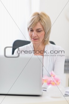 Middle age business woman working on laptop