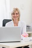 Smiling senior business woman working on laptop